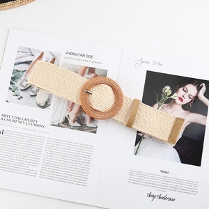 Detail of beige woven straw belt featuring a round wooden buckle on a fashion magazine