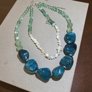 Green acrylic bead layered necklace with irregular marble resin pendant on vintage books