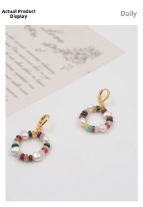 Detail of colorful checkerboard stone hoop earrings with irregular pearls on white base