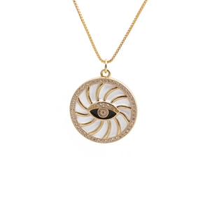 Close-up of gold-plated evil eye necklace pendant with zircon stones and white enamel detail