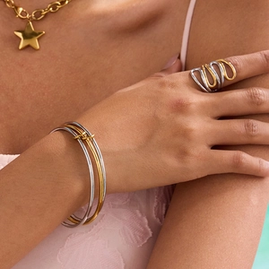 Elegant stainless steel jewelry set with gold and silver bracelets, rings, and star necklace