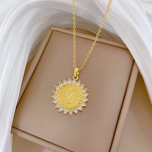 Close-up of a gold-plated necklace with a Virgin Mary pendant and sparkling crystals