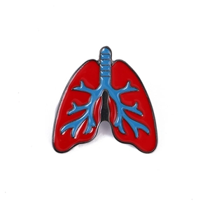 Detailopname van een medische emaille speld in de vorm van een long in rood en blauw