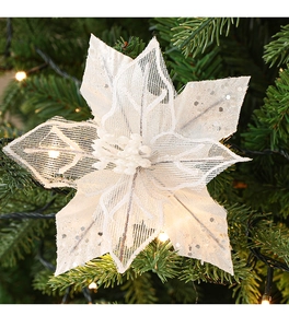 Macro shot of a cream-colored mesh Christmas flower with silver glitter on pine branches