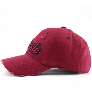 Detail of vintage burgundy cotton baseball cap with 'Classic' embroidery and distressed effects