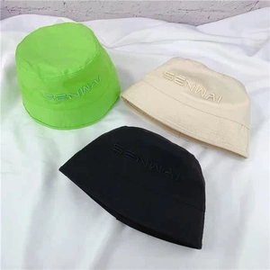 Detail view of cotton bucket hats in green, cream, and black with SENWAI embroidery.