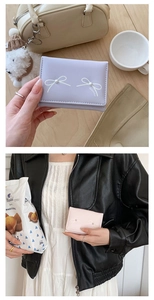 Detail of cute PU leather wallets with bowknot prints and pearls in pink and purple colors