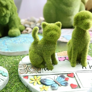 Detail of flocked moss dog figurine with decorative floral stepping stone for garden decor
