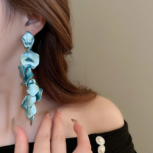 Detail showing long matte blue petal tassel earrings with textured floral design