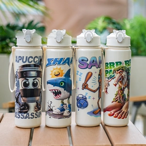 Quatre bouteilles d'eau beiges avec sangles sur une table en bois à l'extérieur