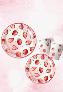 Close-up of strawberry themed disposable paper plates and cups for birthday party