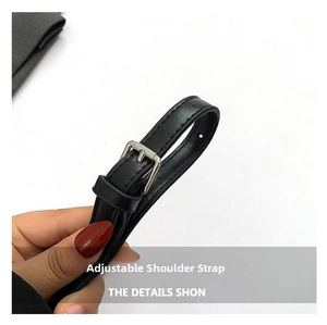 Detail view of adjustable black leather shoulder strap with a silver metal buckle