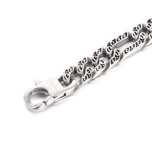 Detail of silver stainless steel Cuban chain lobster clasp and engraved link patterns