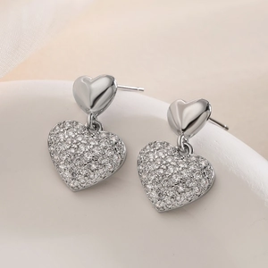 Elegant silver heart drop earrings with sparkling rhinestones on a minimalist white backdrop