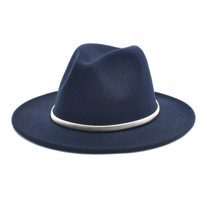 Detail of navy blue wool fedora hat with gold metal decorative band and wide brim