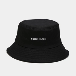 Close-up of THE FOCUS white embroidery and reinforced stitching on a black cotton bucket hat