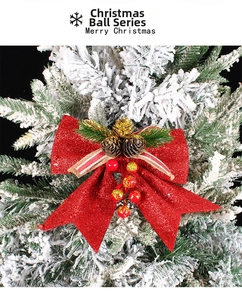 Détail d'un nœud de Noël rouge scintillant avec mini pommes de pin et baies sur sapin
