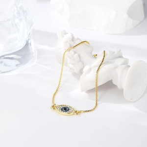 Detail of adjustable evil eye bracelet with blue crystals and gold box chain