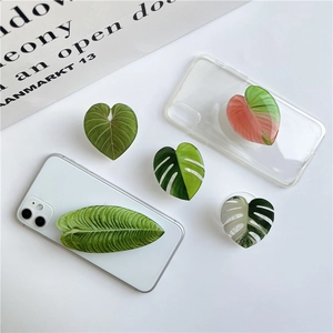 Macro shot of assorted heart and leaf shaped acrylic phone grips on white background