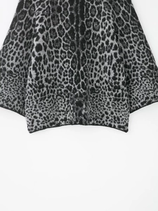 Detailaufnahme des Leoparden-Strickpullover-Saums mit Jacquard-Textur und grauen Tönen