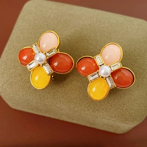 Gros plan de boucles d'oreilles vintage fleurs avec gemmes colorées et perle
