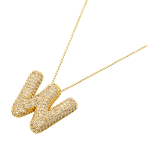Close-up of golden letter W pendant with cubic zirconia stones on box chain
