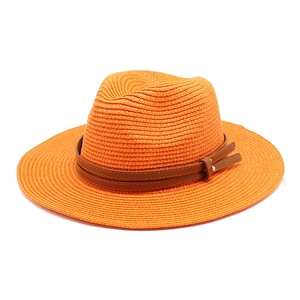 Détail d'un chapeau fedora en paille orange avec double sangle en cuir et boucle en métal