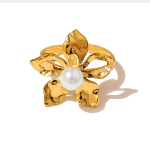 Macro detail of golden flower ring with polished petals and a white pearl center