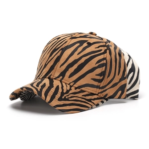 Close-up of stacked baseball caps with brown and white zebra animal print patterns