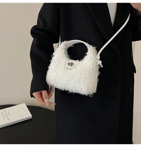 Detail of white faux fur handbag with silver metal twist lock and round handle