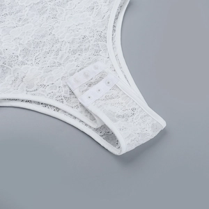 Dettaglio del body in pizzo bianco con chiusura sicura a tre bottoni a pressione sotto