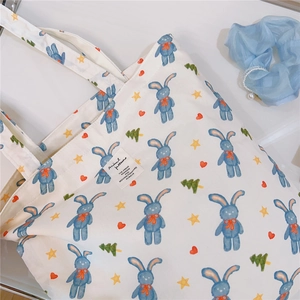 Detailed view of white cotton tote bag featuring cute rabbit print and stitched label