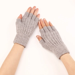 Detailed close-up of light gray cable knit fingerless gloves with ribbed elastic cuffs