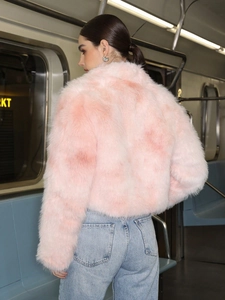 Manteau chic en fausse fourrure rose pour femme avec jean bleu dans le métro
