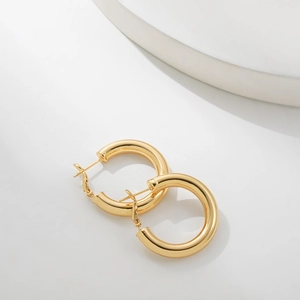 Detailed close-up of chunky 18K gold-plated stainless steel hoop earrings with polished finish