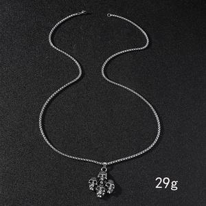 Détail macro du collier pendentif crâne en acier inoxydable argenté pesant 29g sur fond noir