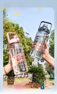 Outdoor close-up of 2L sports water bottle with straw and hydration time markers
