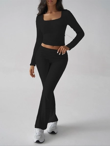Détail d'un haut court noir à manches longues et d'un pantalon évasé à taille haute de yoga