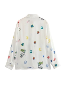 Détail de la vue arrière d'une chemise blanche à manches lanterne avec graffitis colorés
