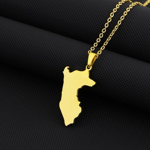 Primo piano di un ciondolo a mappa del Perù color oro lucido su sfondo nero tramato