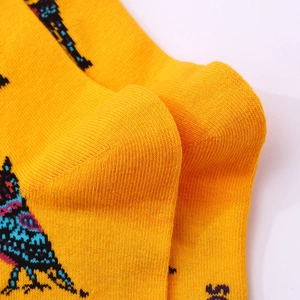 Leuchtend gelbe Strick-Socken mit buntem Vogelmuster für Halloween und Tag der Toten