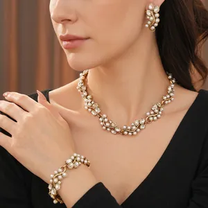 Vintage gold jewelry set with oval pearls and sparkling rhinestones worn by a model