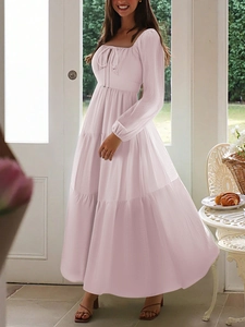 Chic pink tiered maxi dress with long sleeves and bow detail for resort vacations