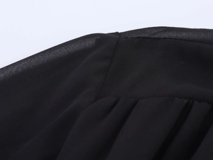 Gros plan détaillé montrant les coutures et la texture du tissu en mousseline noire