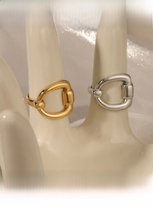 Détail des bagues mors en or et argent sur un modèle de main de mannequin blanc