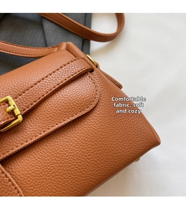 Detail of brown litchi pattern leather bag showing precise stitching and gold buckle