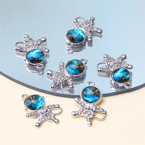 Detailed view of silver astronaut pendants with blue starry pattern and crystal accents