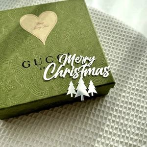 Detailed view of green luxury embossed gift box with a golden heart-shaped Christmas tag