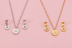 Detailed view of silver and gold titanium steel jewelry sets with Roman numeral crystals