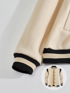 Detailed close-up of the striped ribbed cuffs and hem of this casual varsity jacket